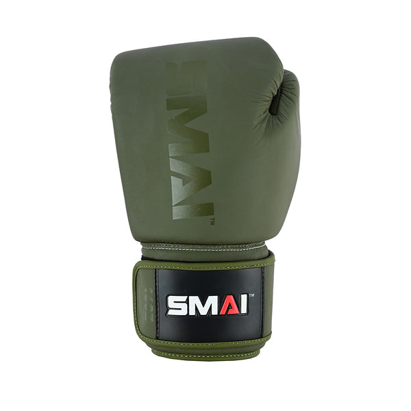 The Elite85 Boxing Glove by SMAI in olive green features “SMAI” branding on the glove and wrist strap, is designed to reduce injury, and is shown upright on a white background.