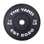 The Yard - HD Bumper Plates (Pair) - 15kg by SMAI: Black, made from high-density virgin rubber, with white "THE YARD" text, “15 KG,” “35 LB,” and “EST 2020.” Metallic center hole—perfect for any home gym.
