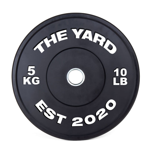 The SMAI The Yard - HD Bumper Plate (Pair) 5kg features a black design with "THE YARD" at the top, "5 KG" left, "10 LB" right, and "EST 2020" below, plus a silver center—ideal for Olympic or CrossFit training.