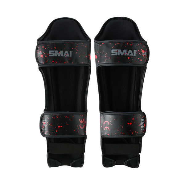 The SMAI Muay Thai Shin Instep Guard - Black Dragon features a red splatter design, adjustable straps, and protective padding—perfect for style and reliable protection in Muay Thai.