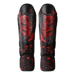 The SMAI Muay Thai Shin Instep Guard - Black Dragon features vibrant red dragon designs and splatter patterns on durable synthetic leather, displayed from the front against a white background.