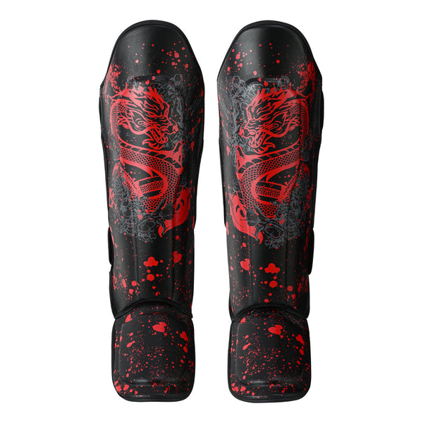 The SMAI Muay Thai Shin Instep Guard - Black Dragon features vibrant red dragon designs and splatter patterns on durable synthetic leather, displayed from the front against a white background.