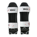 The SMAI Muay Thai Shin Instep Guard - White Dragon is a pair of white shin guards with black padding, red splatter design, labeled "Left" or "Right," EVA foam protection, top strap SMAI logo, and Velcro straps for ankle and calf.