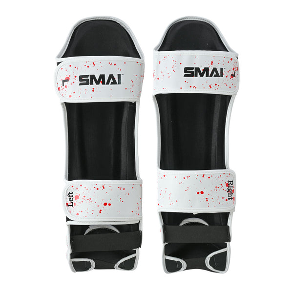 The SMAI Muay Thai Shin Instep Guard - White Dragon is a pair of white shin guards with black padding, red splatter design, labeled "Left" or "Right," EVA foam protection, top strap SMAI logo, and Velcro straps for ankle and calf.