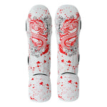The SMAI Muay Thai Shin Instep Guard - White Dragon features bold red dragon graphics and red paint splatter on a white base, with EVA foam protection for superior comfort. Displayed side by side, facing upward.