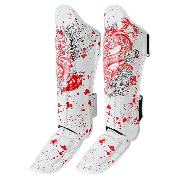 The SMAI Muay Thai Shin Instep Guard - White Dragon features white guards with red splatter, detailed red dragon designs, EVA foam protection, black floral accents, and adjustable black side straps.