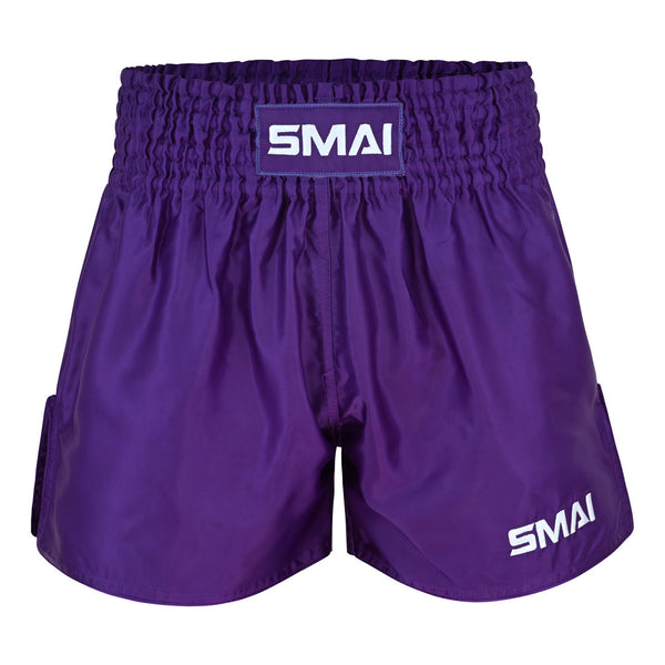 SMAI Muay Thai Shorts - Purple feature a wide, gathered elastic waistband for a secure and comfortable fit. These unisex shorts display the SMAI brand name in bold white letters on both the waistband and lower left leg.