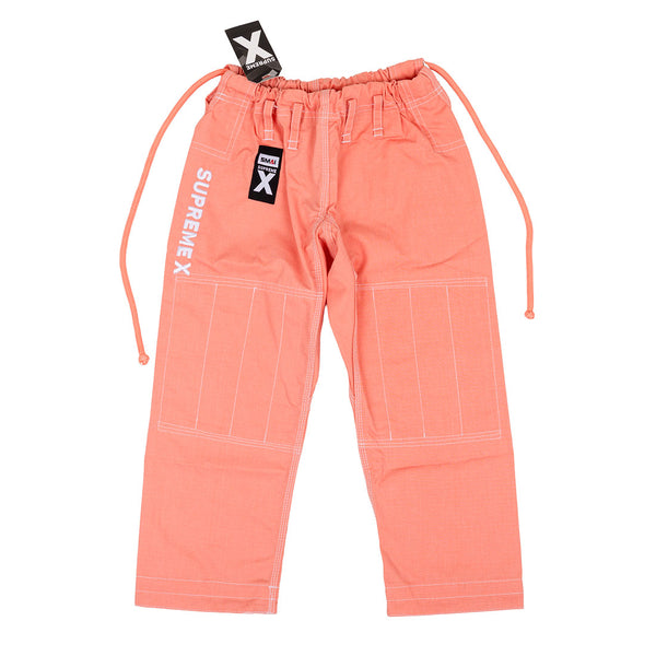 The SMAI Supreme X Brazilian Jiu Jitsu Uniform - Salmon pants feature white stitching, a drawstring waistband, "SUPREMEX" on the left leg, durable pearl weave fabric, and tagged waistband for youth martial arts training.