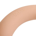 A close-up of the SMAI Pilates Weighted Bar Blush Pink 7kg shows its beige circular end with "SMAI" embossed, featuring a smooth finish and partially visible against a white background.