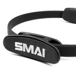 A close-up of the black SMAI Pilates Ring / Yoga Ring - Commercial Grade, featuring the white SMAI logo on a padded section—perfect for resistance training and toning workouts.