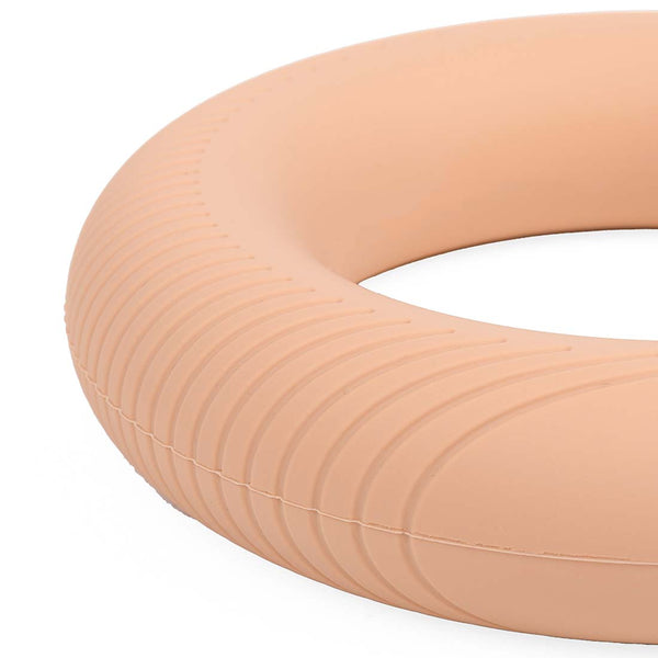 A close-up of the SMAI Pilates Power Ring Blush Pink 2.5kg, featuring a textured blush pink surface with subtle ridges, reminiscent of Pilates equipment, set against a white background.