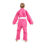 A young child stands barefoot facing away in an SMAI Supreme X Brazilian Jiu Jitsu Uniform in pink with a white belt, set against a plain white background.