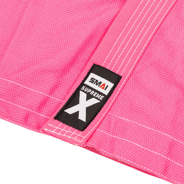 Close-up of the SMAI Supreme X Brazilian Jiu Jitsu Uniform in pink, made from durable Rip Stop fabric with white stitching and a black "SMAI SUPREME X" patch.