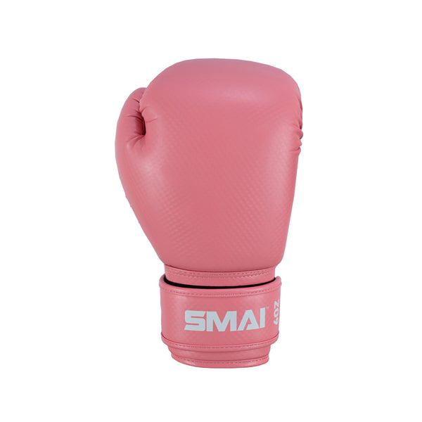 The PRE ORDER: Essentials Kids Boxing Glove - Pink by SMAI is a single pink kids glove made from synthetic leather, with a textured surface, wide wrist strap for support, and the SMAI brand in white lettering.