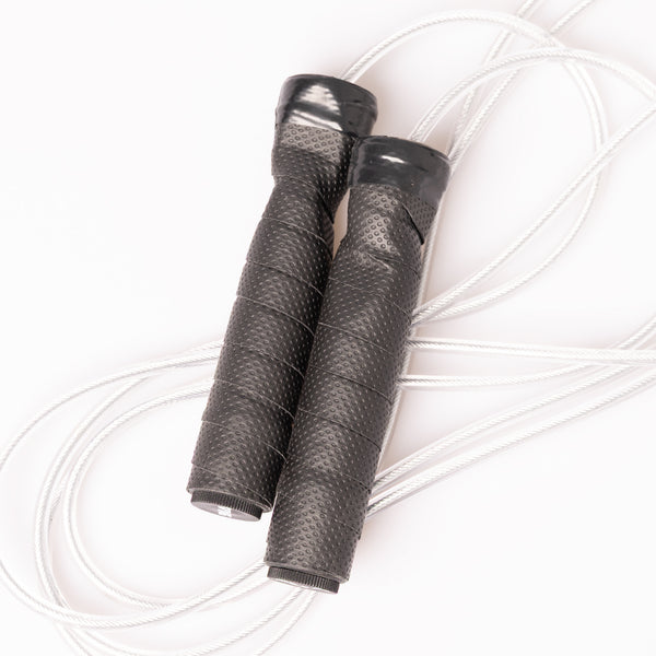A SMAI Skipping Rope with Weighted Handles featuring two black, textured weighted handles coiled on a white surface.