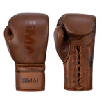 The SMAI Pro Series Leather Lace-Up Boxing Glove in Antique Brown is shown: one displays the palm with laces, the other shows the branded back. Both feature velcro wrist straps and a smooth, classic design for superior impact absorption.