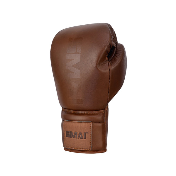The SMAI Pro Series Leather Lace-Up Boxing Glove in Antique Brown features visible stitching and the "SMAI" logo on the wrist strap, crafted from premium cowhide leather and displayed against a plain white background.