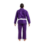 A person stands barefoot, facing away from the camera, wearing an SMAI Supreme X Brazilian Jiu Jitsu Uniform in purple with reinforced stitching and a white belt, set against a plain white background.