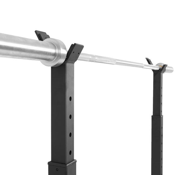 A close-up of the SMAI Portable Squat Stand - Heavy Duty with a metallic barbell, featuring adjustable holders—ideal for any home gym—set against a plain white background.