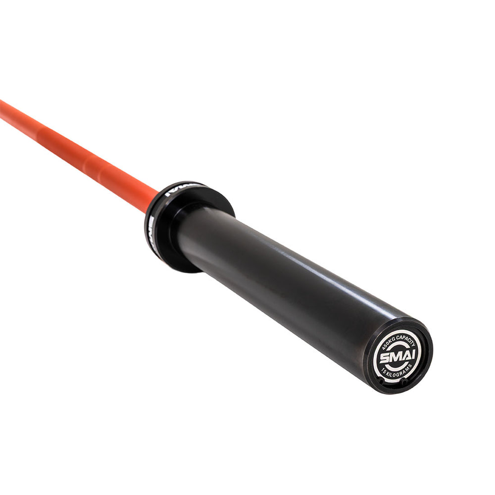 A close-up of the SMAI Barbell - Red Ceramic Coat - 15kg shows its black sleeve, vivid red shaft, and branded end cap, emphasizing the premium ceramic coating and quality finish.