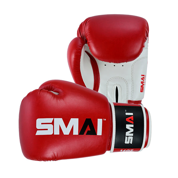 The SMAI Essentials Red Boxing Glove features bold branding on the wrist strap and glove. One glove stands upright while the other lies flat, ideal for sparring or practice sessions.