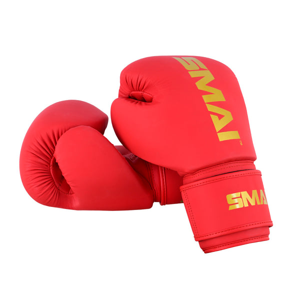 A pair of SMAI Gold Series Boxing Gloves in red and gold, featuring yellow "SMAI" branding on the wrist straps and top, are shown against a white background. Designed for superior shock protection.