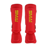 A pair of SMAI Gold Series Muay Thai Shin Guards in red/gold with vertical yellow "SMAI" branding, featuring multi-layer EVA protection for martial arts safety, shown against a white background.