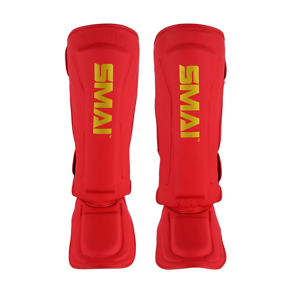 A pair of SMAI Gold Series Muay Thai Shin Guards in red/gold with vertical yellow "SMAI" branding, featuring multi-layer EVA protection for martial arts safety, shown against a white background.