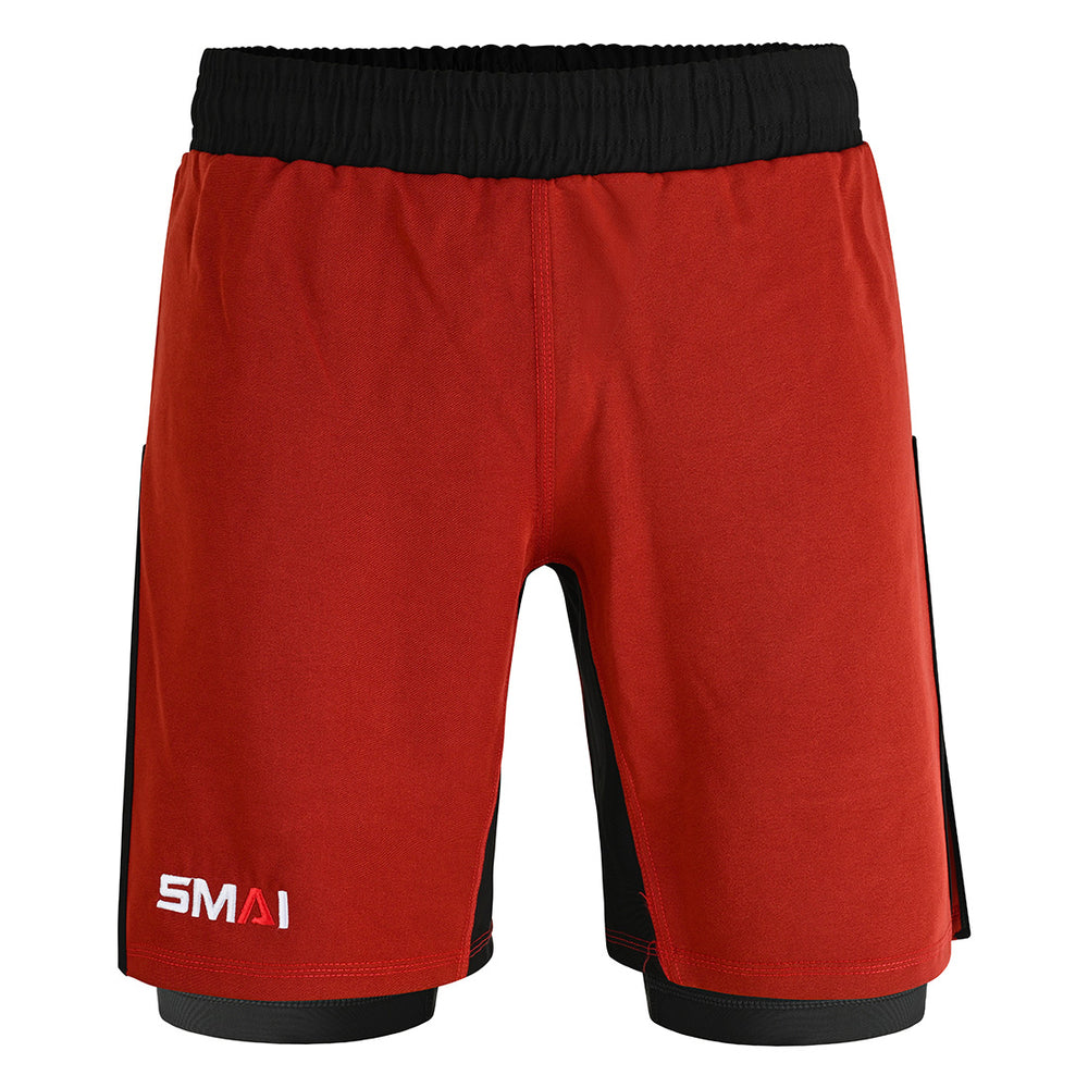 The SMAI Hybrid MMA Grappling Shorts in black/red feature a black waistband, black side panels, a white “SMAI” logo on the front left leg, and a fitted underlayer at the hem for comfort during tough training.