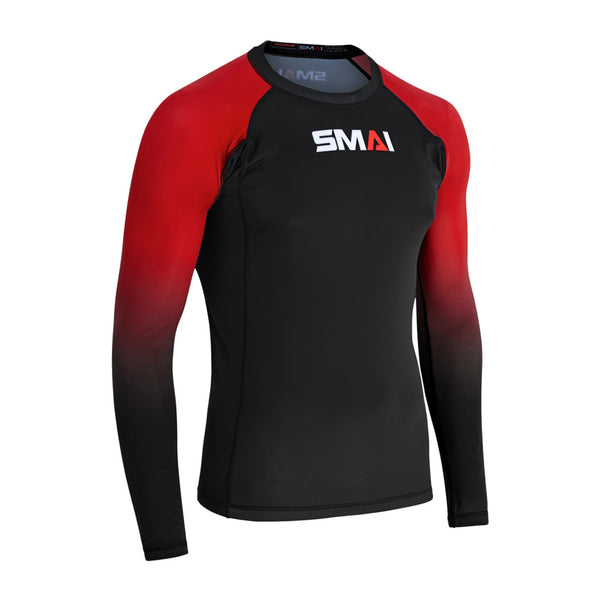 The SMAI Long Sleeve Rash Guard - Red features a black body, red-to-black gradient sleeves, and "SMAI" printed in white, red, and gray on the chest. Designed for no-gi grappling with advanced compression. Shown on a plain white background.
