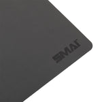 A close-up of the SMAI Pilates Reformer Carriage Topper / Protector, a rectangular black mat with rounded edges. The "SMAI" logo is printed near the corner, highlighting its sleek design for Reformer protection.
