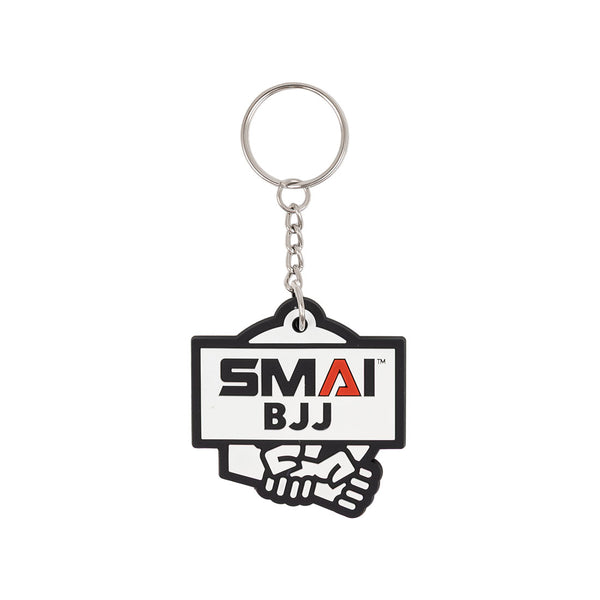 The SMAI BJJ Keyring - Rubber by SMAI features a metal ring and a tag with "SMAI BJJ" above two gripping hands, representing Brazilian Jiu-Jitsu.