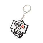 The SMAI BJJ Keyring - Rubber features the bold SMAI BJJ logo on a white background above two hands in a handshake, and comes with a sturdy silver ring.