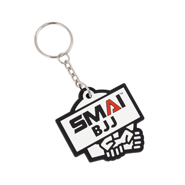 The SMAI BJJ Keyring - Rubber by SMAI features a metal ring and a tag with "SMA BJJ" above two clasped hands, symbolizing Brazilian Jiu-Jitsu.