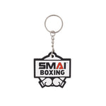 The SMAI Boxing Keyring - Rubber features "SMAI BOXING" text, a boxing gloves graphic, and includes a silver chain and ring—ideal for fans or athletes.