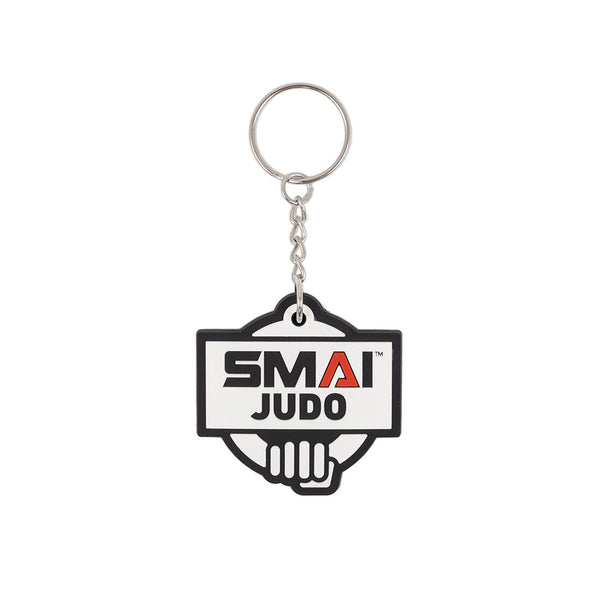 The SMAI Judo Keyring - Rubber by SMAI features a rectangular rubber tag with "SMAI JUDO" in bold above a stylized hand graphic, attached to a metal ring and chain.
