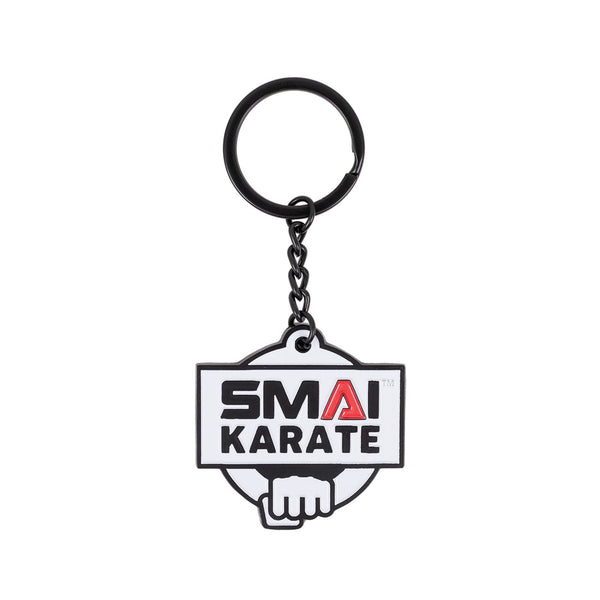 The SMAI Karate Keyring - Metal features a black ring and a rubber tag displaying "SMAI KARATE" in black and red above a clenched fist illustration.