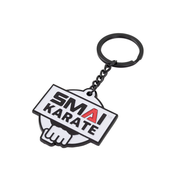 The SMAI Karate Keyring - Metal features a black metal ring and chain with a white tag displaying "SMA KARATE" in bold black and red letters above a fist design—perfect for any SMAI enthusiast.