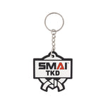 The SMAI Taekwondo Keyring - Rubber features a rectangular SMAI TKD logo with a martial arts belt design, attached to a sturdy metal ring and chain.