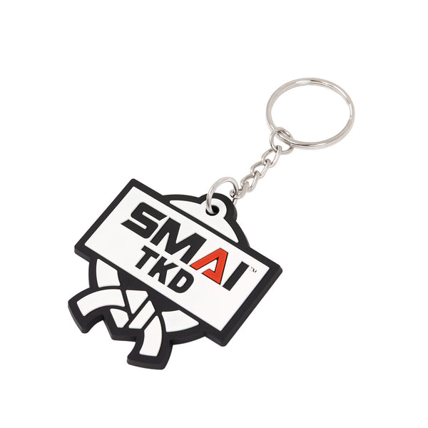 The SMAI Taekwondo Keyring - Rubber by SMAI features a metal ring, a rubber tag with bold "SMAI TKD" in black and red, and a white martial arts belt illustration below the text.