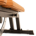 A close-up of the durable black metal frame and tan padded seat of the SMAI Commercial Adjustable Bench, shown against a white background.