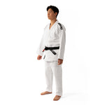 A person stands barefoot on a white background, wearing a white gi with black trim and an SMAI Brazilian Jiu-Jitsu Belt – IBJJF Standard around the waist.