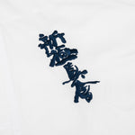 Close-up of the SMAI Kin Kyokushin Uniform - 8oz Student Gi, featuring white fabric with black embroidered Japanese kanji characters.