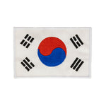 The SMAI Badge - Korean Flag features a rectangular embroidered design with the red and blue yin-yang center, four black trigrams on white, and is perfect as an iron-on addition to your collection.