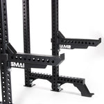 Close-up of a black adjustable gym rack with a quick release safety pin system and multiple holes for customization. Featuring "SMAI" on the supports, it also includes Safety Spotter Arms (Pair) - Vanta Series for added security. Set against a plain white background, the rack ensures reliability and versatility.