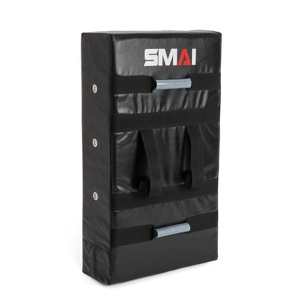 The SMAI Kick Shield - Shoc Tec Straight is a black rectangular martial arts pad featuring reinforced stitching, sturdy handles, and the brand name "SMAI" printed on it for secure gripping during training.