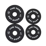 Four black SMAI The Yard - 7.5kg Fractional Plates ("THE YARD EST 2020" in white), in 2.5kg/5lb and 1.25kg/2.5lb sizes, are arranged in a square on a white background—ideal for micro-loading your lifts.