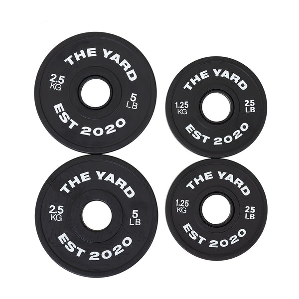 Four black SMAI The Yard - 7.5kg Fractional Plates ("THE YARD EST 2020" in white), in 2.5kg/5lb and 1.25kg/2.5lb sizes, are arranged in a square on a white background—ideal for micro-loading your lifts.