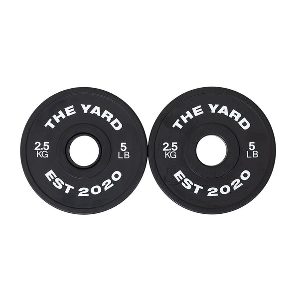 Two black SMAI plates from The Yard - 7.5kg Fractional Plate Set, labeled "THE YARD EST 2020," "2.5 KG," and "5 LB" in white—ideal fractional plates for micro-loading weight adjustments.