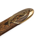 A close-up of the SMAI Tai Chi Sword Brass Fitting Ying Yang handle, showcasing a brass ornament with a swirl pattern and visible wood grain texture.